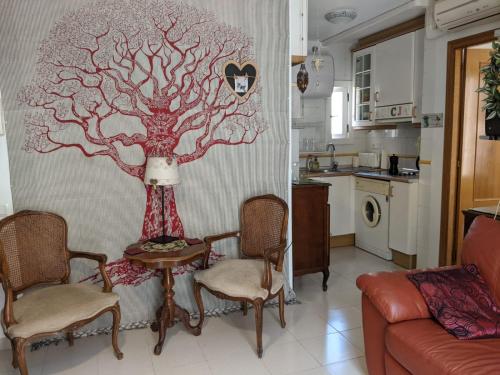 a living room with a tree mural on the wall at Apartament Elizabet in Tarragona