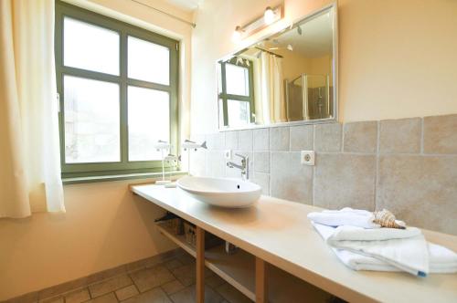 un bagno con lavandino e specchio di Ferienwohnung Am Leuchtfeuer EG a Wustrow