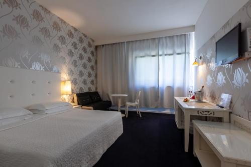 a hotel room with a bed and a desk at Hotel Mediterraneo in Riccione