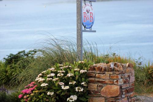 a street sign on a pole next to a rock wall at Clifden Bay Lodge in Clifden
