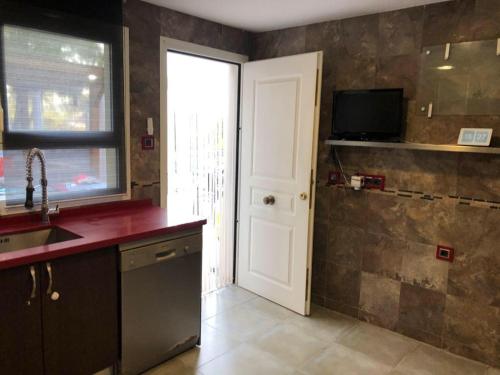 a kitchen with a sink and a white door at Urbanizacion El Pantano villa 4 dormitorios in Alcora