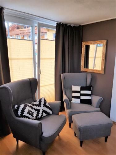 two chairs and a ottoman in a living room at Haus Montana in Lermoos