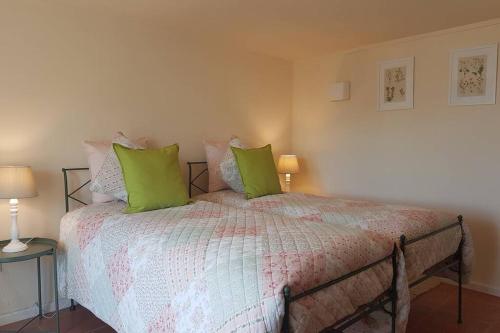a bedroom with a large bed with green pillows at Casa de Campo - Cinfães do Douro in Cinfães