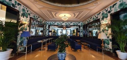 a dining room with blue chairs and plants at Principe Pio in Madrid