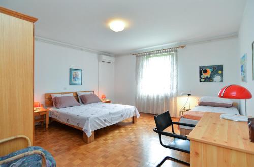 a bedroom with two beds and a table and a desk at Apartment Anton 2083 in Premantura