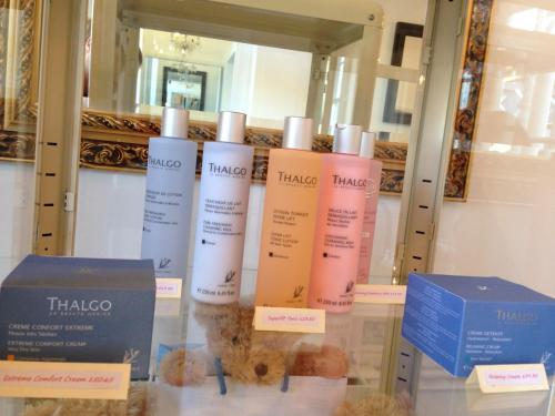 a group of three moisturizers on a glass table in front of a mirror at Thanington Hotel in Canterbury
