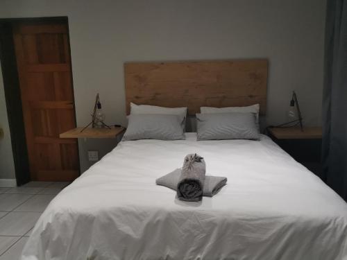 Una cama blanca con una toalla encima. en Leopolds Rest, en Prieska