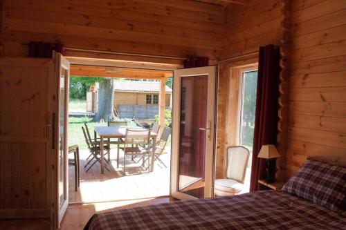 - une chambre avec un lit et une terrasse avec une table dans l'établissement la liberté des hirondelles, à Saint-Laurent-de-la-Barrière