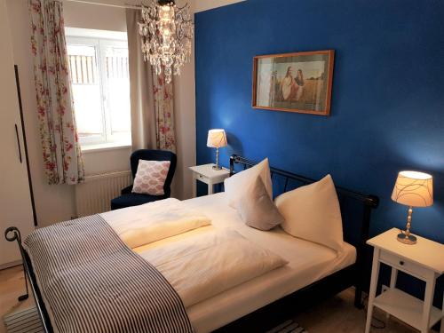 a bedroom with a bed and a blue wall at Haus Montana in Lermoos