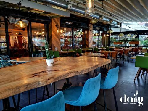 a large wooden table in a restaurant with blue chairs at Queen's Hotel - Zebra Centre in Skopje