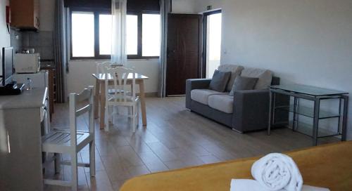 a living room with a couch and a table at Apartamentos na Quinta Altavista do Carvalhal in Zambujeira do Mar