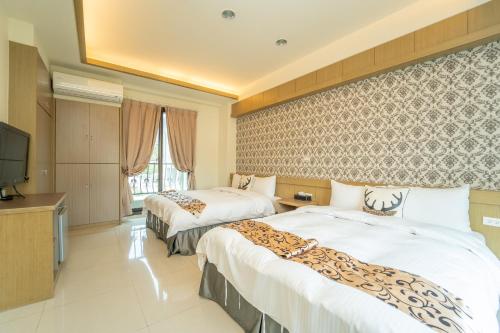 pokój hotelowy z 2 łóżkami i telewizorem z płaskim ekranem w obiekcie Lusihan B&B w mieście Yuchi
