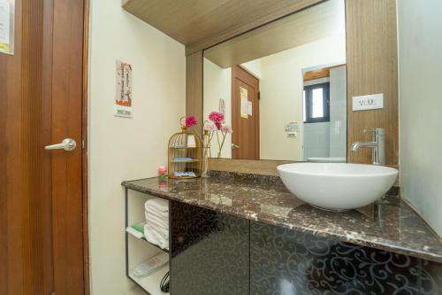 a bathroom with a sink and a large mirror at Lusihan B&B in Yuchi