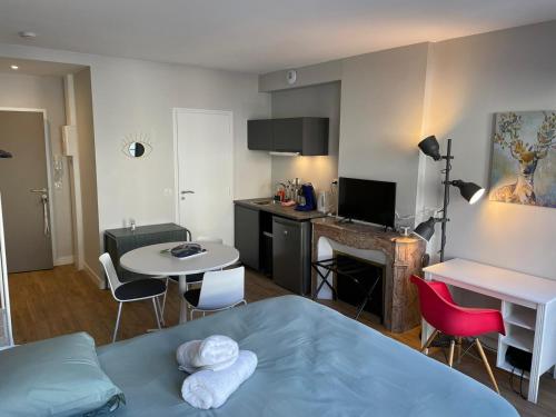 een kamer met een bed en een tafel en stoelen bij Chaleureux studio * Neuf * Hypercentre * Wifi * in Orléans