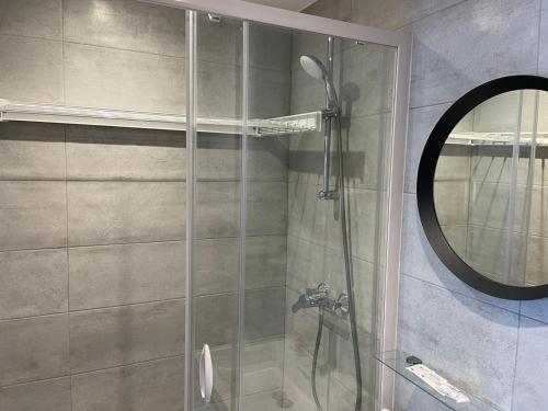 d'une douche avec une porte en verre et un miroir. dans l'établissement Chaleureux studio * Neuf * Hypercentre * Wifi *, à Orléans