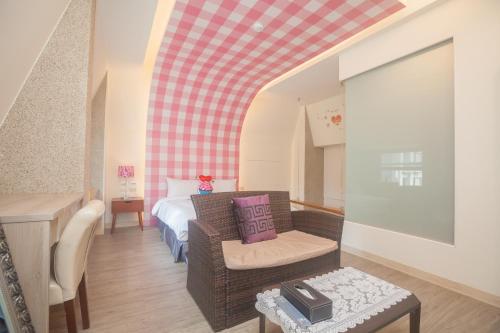 a room with a bed and a chair and a table at Lusihan B&B in Yuchi