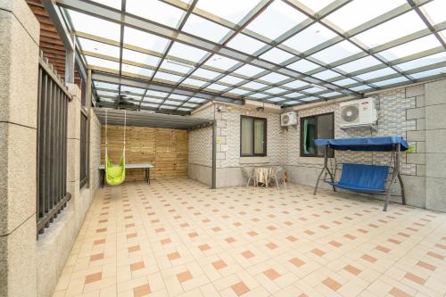 a patio with a glass roof with a table and a chair at Lusihan B&B in Yuchi