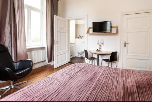 a room with a bed and a table with chairs at Schloss Harkensee in Dassow