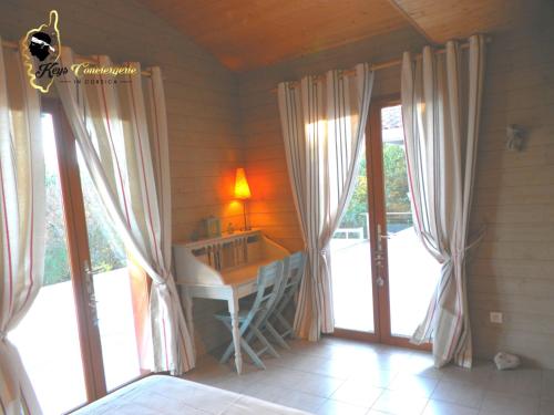 Cette chambre dispose d'un bureau et de fenêtres. dans l'établissement Dormir à Porto Vecchio (Trinité), à Porto-Vecchio