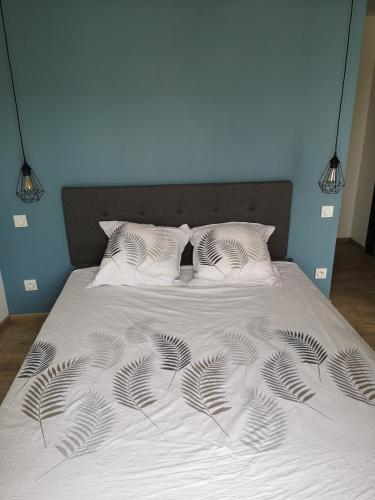 - un lit avec une couverture blanche et une plante dans l'établissement MAISON DU GABAS D'ANNA & ROSE, à Limendous