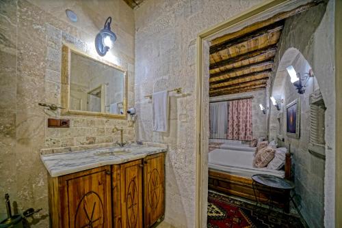 a bathroom with a sink and a mirror and a tub at Elysee Cave House in Goreme