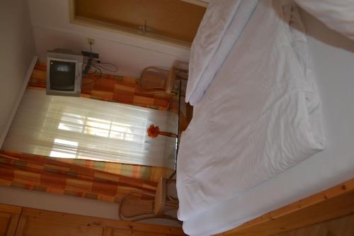 a bedroom with a bed with white sheets and a window at Haus Rohskopf in Mallnitz
