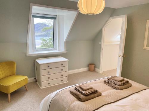 a bedroom with a bed with a chair and a window at Shepherd Moon in Talmine