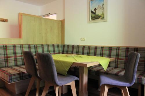 a dining room with a table and four chairs at Ferienhotel Samerhof in Pfarrwerfen