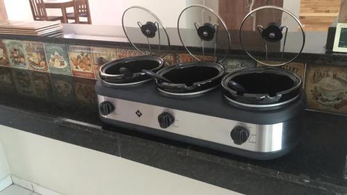 a stove with four pots on top of it at Pousada Alto Mar in Matinhos