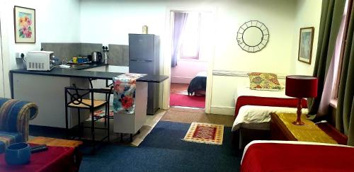 a small room with a kitchen and a refrigerator at Kelkiewyn Guesthouse Caledon in Caledon