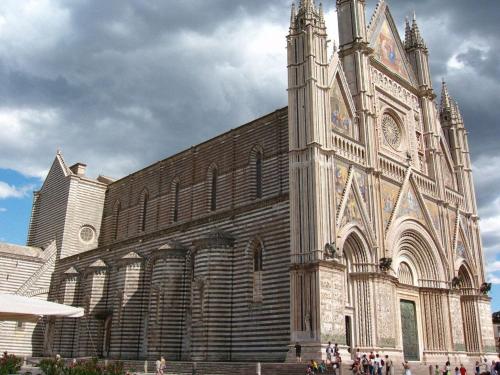 a large church with a clock tower on the side of it at Hotel La Torricella in Capalbio