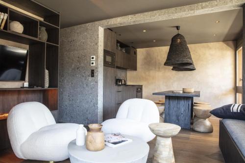 a living room with white chairs and a table at Apartment FERRONNE by JAPANDI home in Megève