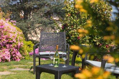 a black chair with a bottle of wine on a table at Un sogno sul lago Home Relax in Stresa