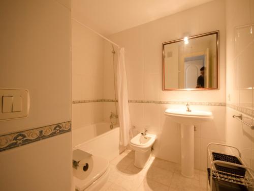 een badkamer met een wastafel, een toilet en een spiegel bij Apartamento Pilar in Marbella