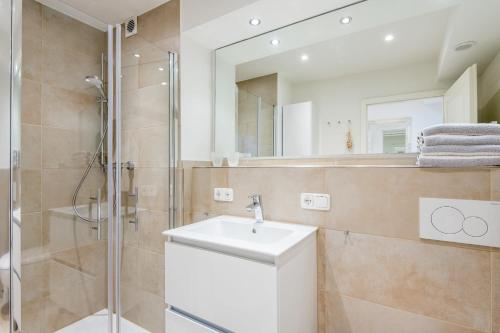 ein Bad mit einem Waschbecken und einer Dusche in der Unterkunft Haus Atrium Wohnung 19 in Westerland