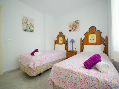 two beds in a white room with two bedsskirts at Apartamento Vistamar in Marbella