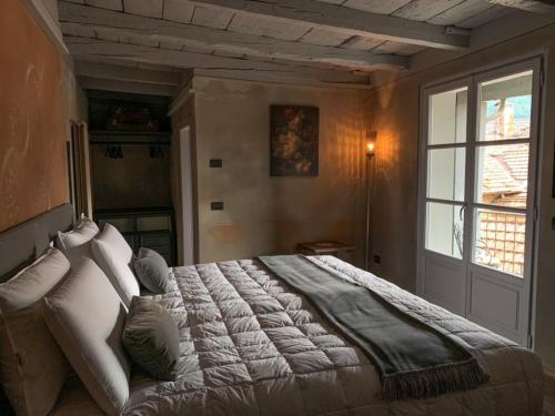 a bedroom with a large bed and a window at DIMORA SCURONE in Cannobio