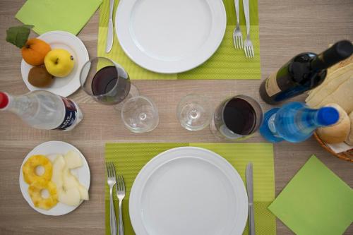 a table with white plates and glasses of wine at Pegasus Hotel in Sassari