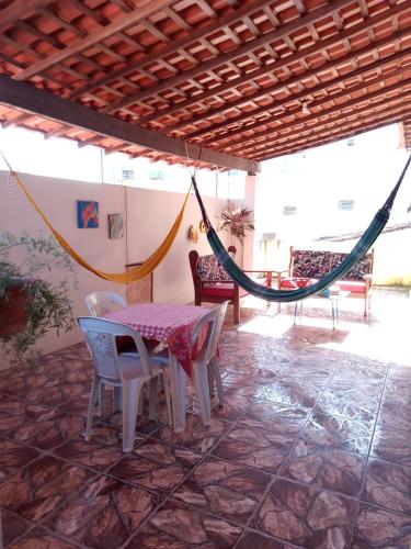 a hammock in a room with a table and chairs at Pousada Novo Horizonte in Barreirinhas
