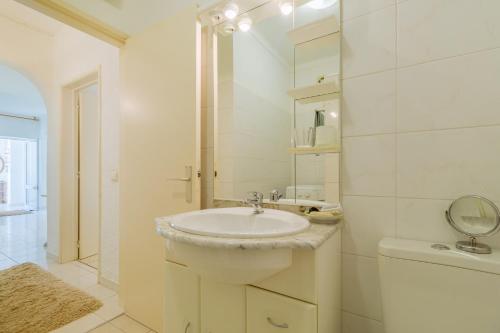 a white bathroom with a sink and a mirror at Apartment Casa Cristiano in Carvoeiro