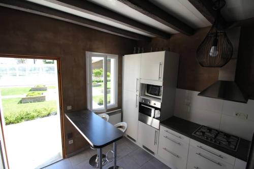 a kitchen with a table and a stove top oven at Gîte LES DOUCESHEURES- 110m²--3 chambres-6 pers in Betz-le-Château