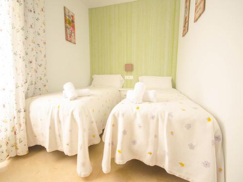1 Schlafzimmer mit 2 Betten und weißer Bettwäsche in der Unterkunft Bungalow Sergio in Estepona
