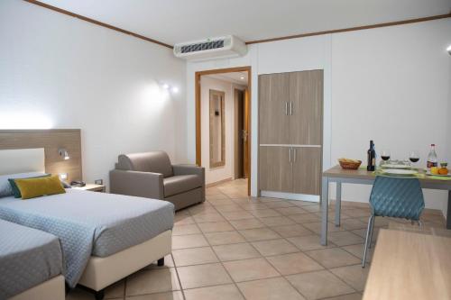 a hotel room with a bed and a chair and a desk at Pegasus Hotel in Sassari