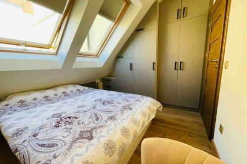 an attic bedroom with a bed and a window at COZY,STYLISH,MODERN APT WITH TERRACE/TOP LOCATION in Sofia