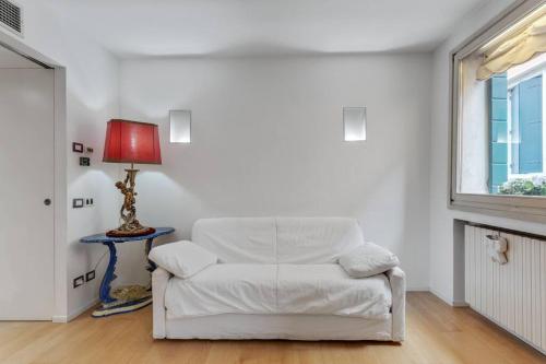a white couch in a living room with a lamp at Easylife - Amazing apartment at Rialto Venezia in Venice