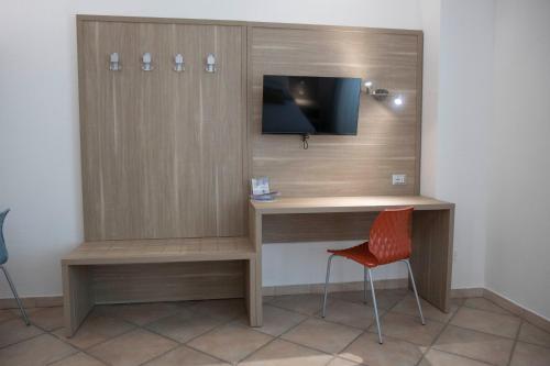 a room with a desk with a tv and a chair at Pegasus Hotel in Sassari