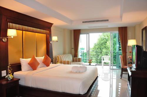 a hotel room with a bed and a balcony at August Suites in Pattaya