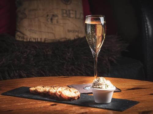a glass of champagne and some food on a table at Logis Le Fleuray in Cangey