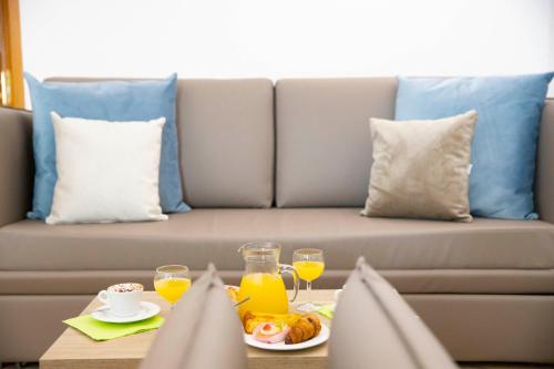 a couch with a table with food and orange juice at Pegasus Hotel in Sassari