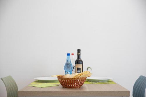 a table with two bottles of wine and a basket of chips at Pegasus Hotel in Sassari